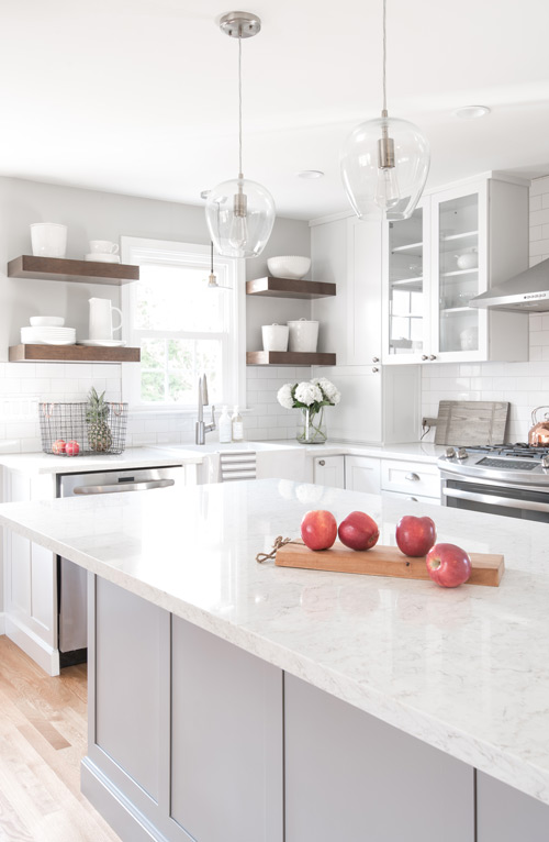 traditional white kitchen with glass upper cabinets and dark wood floating shelves