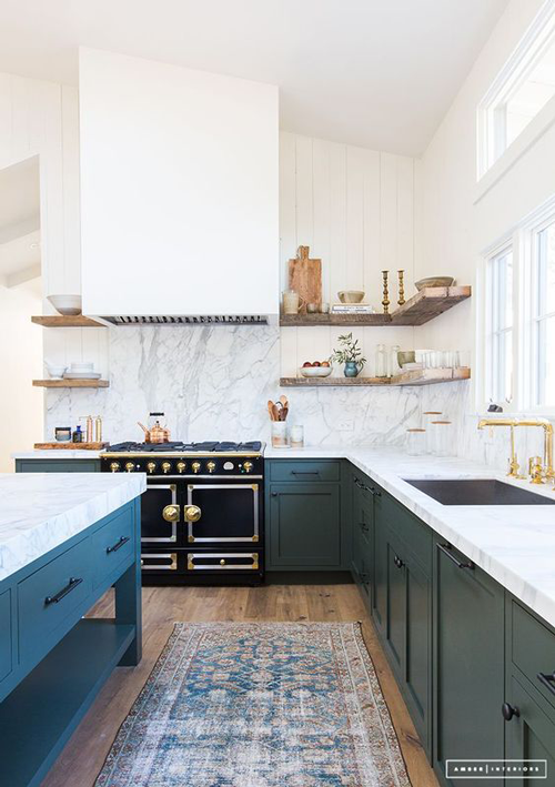 green kitchen with double floating shelves and wood hood